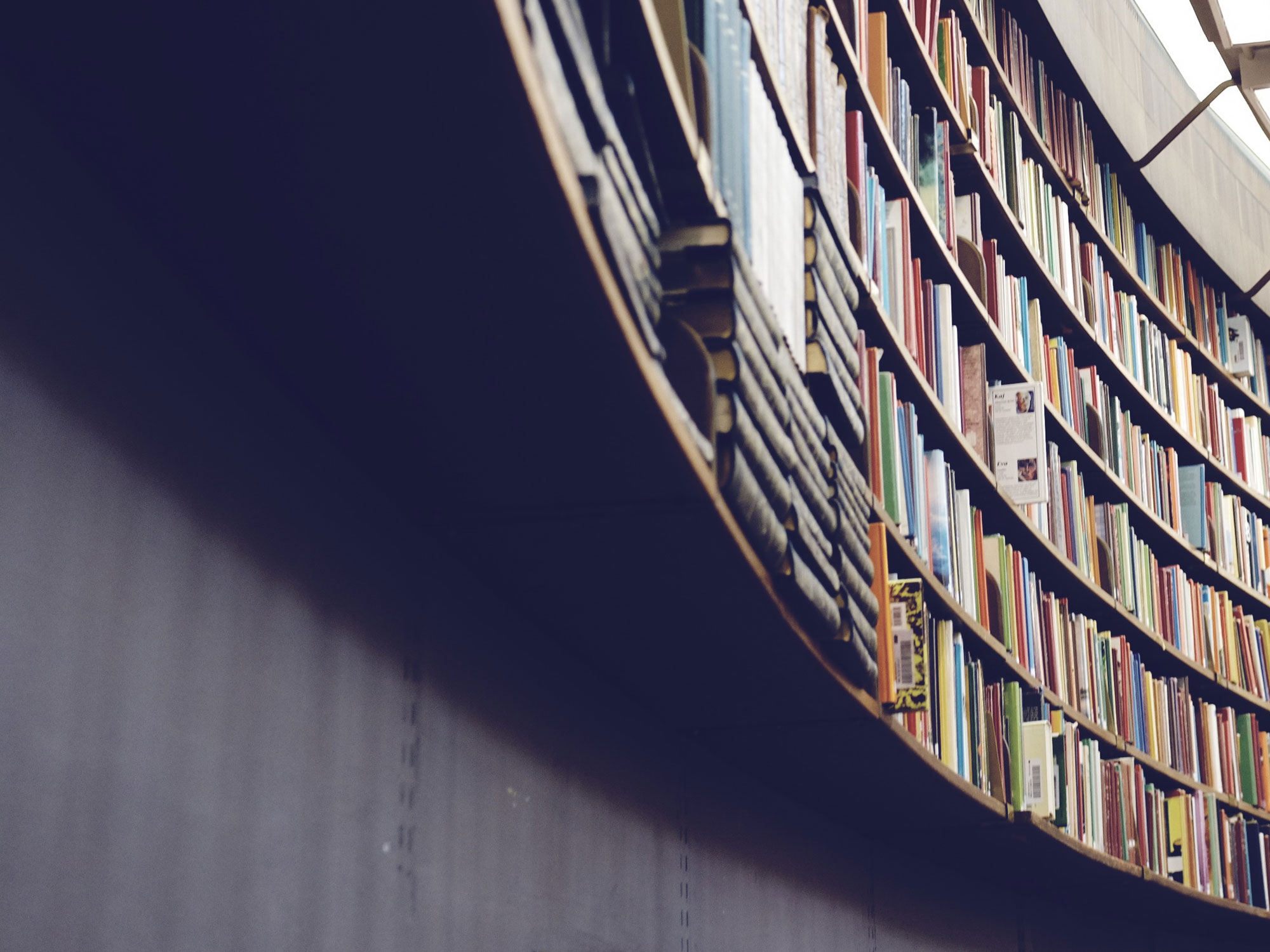 a curved bookshelf as viewed from below